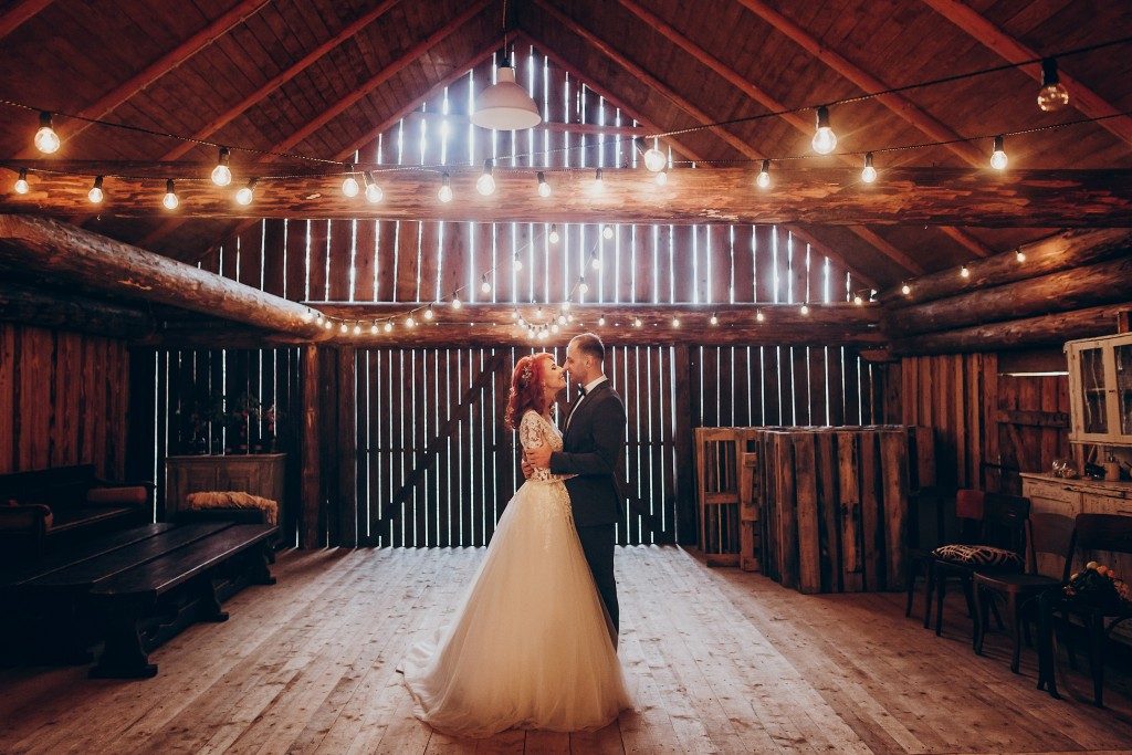 Groom and bride dancing in barn