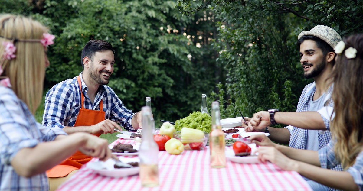 Group of happy people eating food outdoors