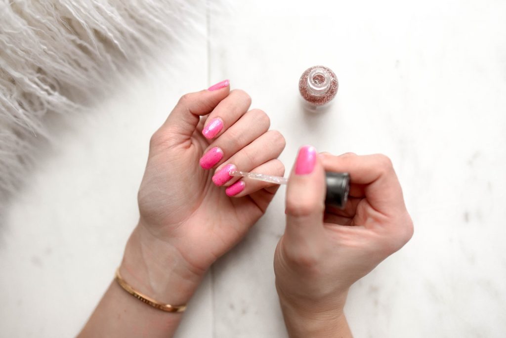 putting-on-pink-nail-polish