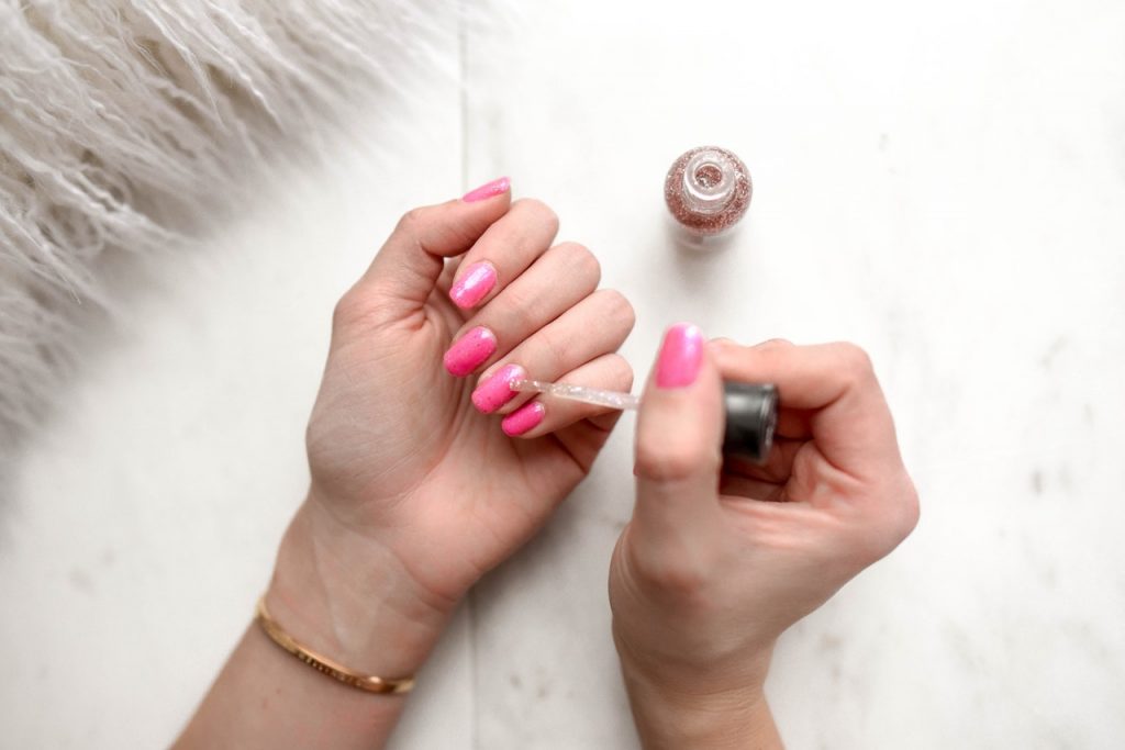 woman applying nail polish to her nails