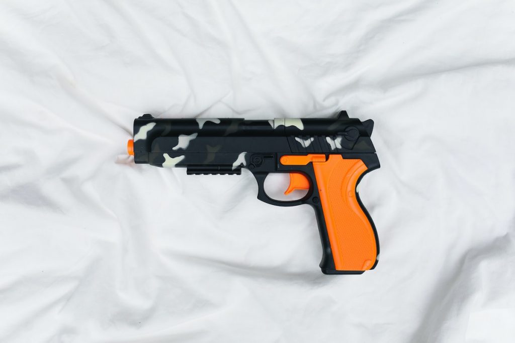 colored gun on a bed