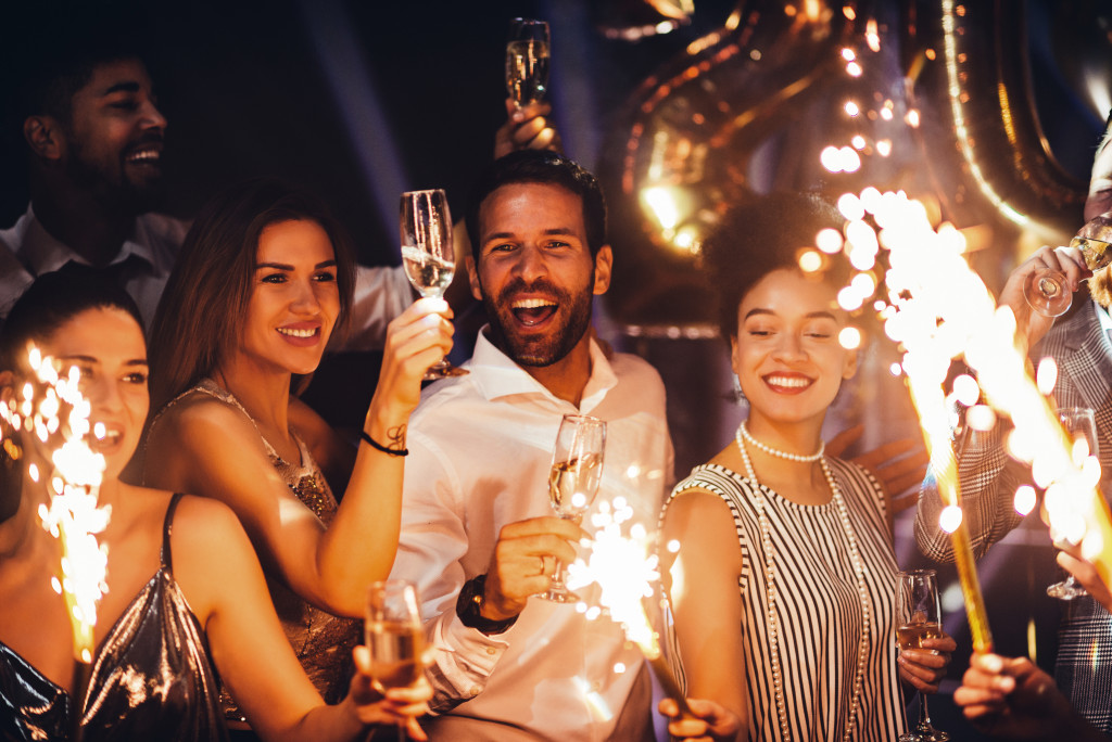 A group of friends holding sparklers and wineglasses