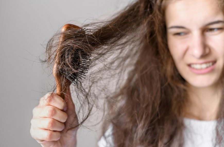 woman struggling with tangled hair caught in a brush